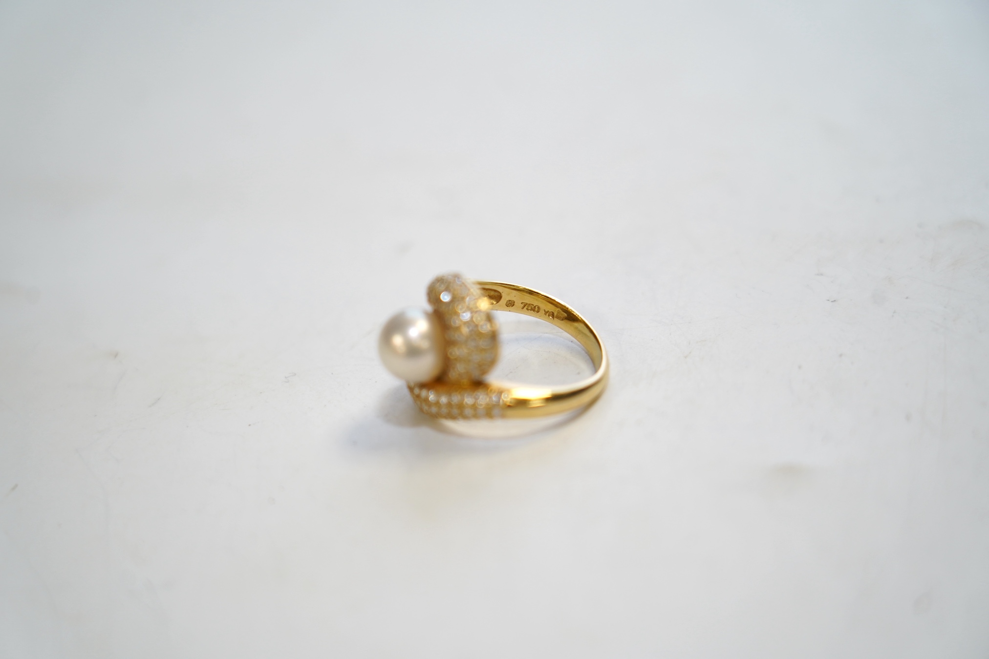 A modern 18ct gold, single stone cultured pearl and diamond chip cluster set dress ring, size M, gross weight 7.5 grams. Condition - good